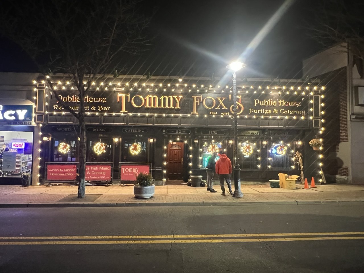 Tommy Fox's pub storefront lit up for the holidays